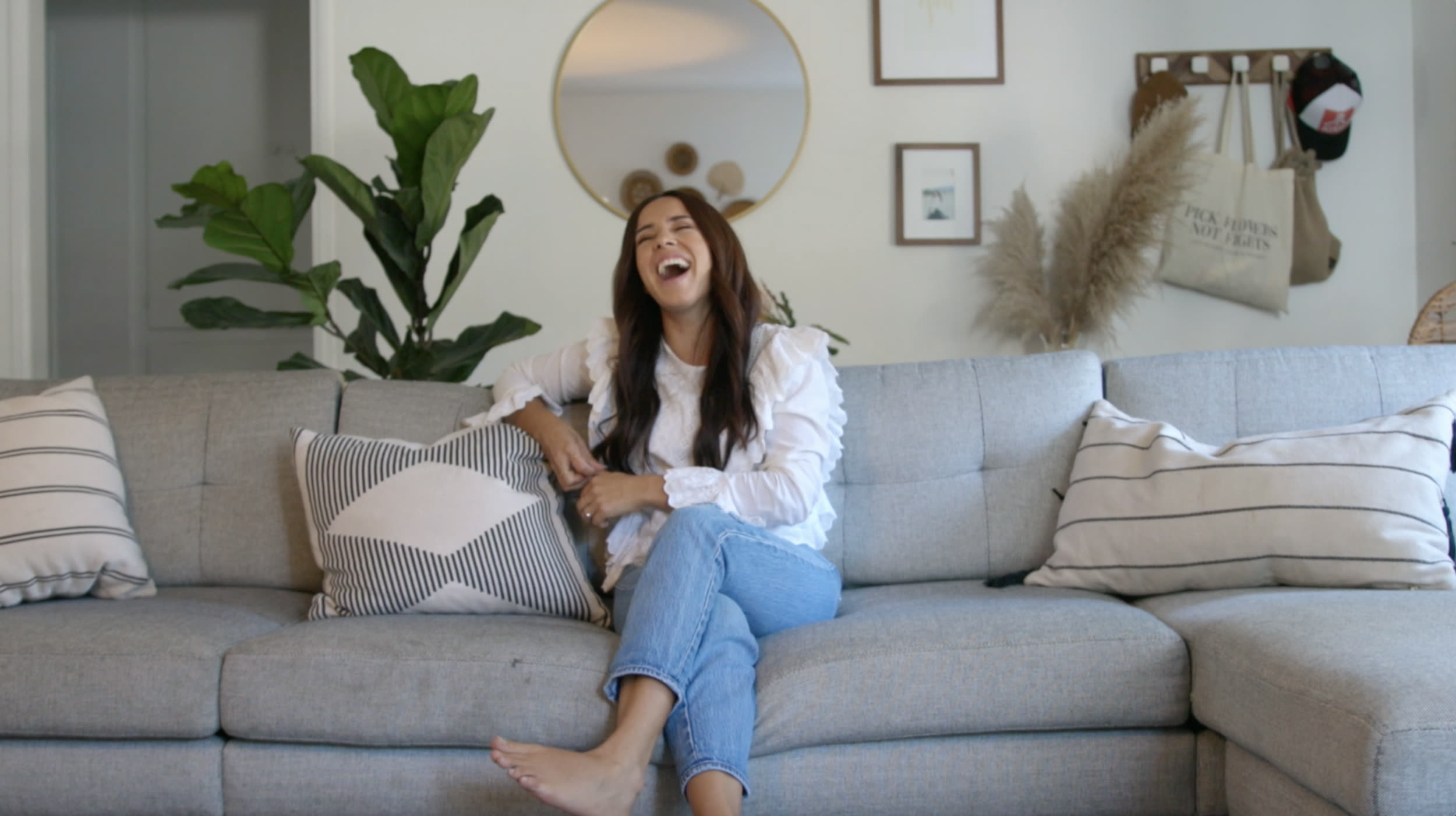 A woman laughing on a couch during a shoot